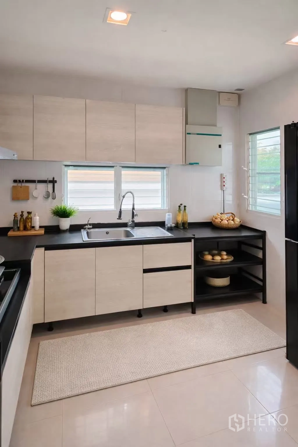 Detached House for rent or sale in Bang Phli, Samut Prakan - Functional kitchen with light wood cabinets, black countertops, sink, and windows.