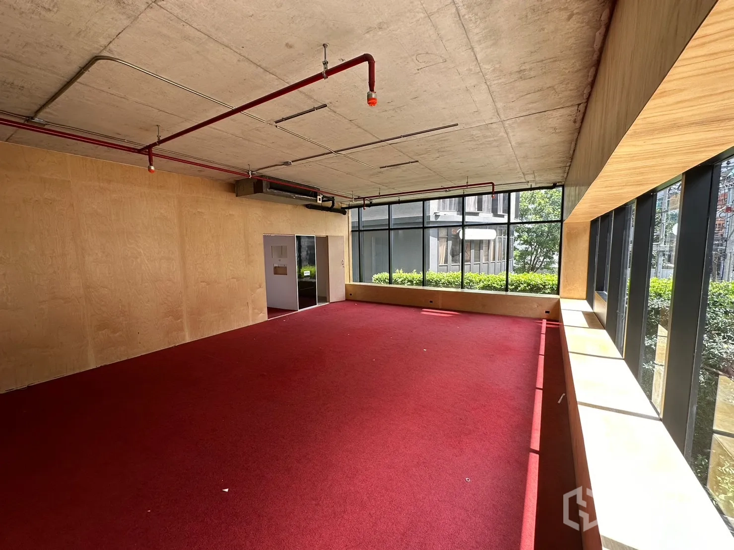 พื้นที่ขายปลีก ให้เช่าในWatthana, Bangkok - ชั้นบนแปลนเปิด ปูพรมสีแดง ผนังไม้ และกระจกเต็มบานรับแสงธรรมชาติ