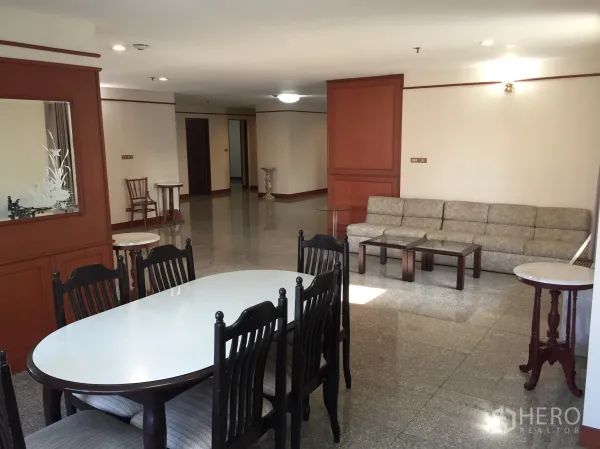 คอนโด ให้เช่าในWatthana, Bangkok - มุมทานอาหารพร้อมโต๊ะรูปวงรี เก้าอี้หกตัว ถัดจากโซฟาที่ยาว ผนังลายไม้และพื้นเงาในห้องนั่งเล่นขนาดใหญ่