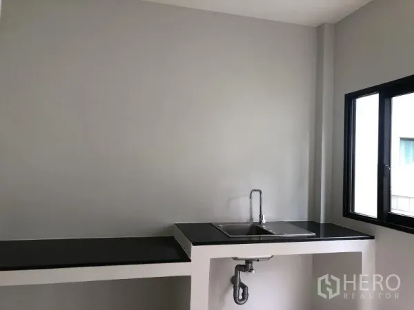 Detached House for sale in Bang Phli, Samut Prakan - Minimalist kitchen with black countertop, sink and side window