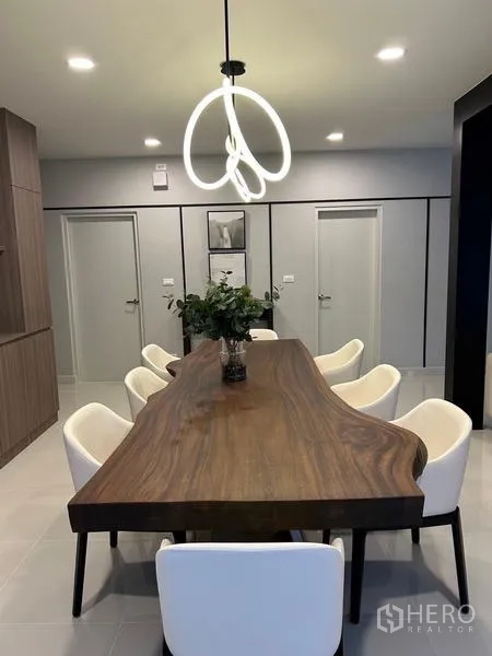 Detached House for rent or sale in Bang Phli, Samut Prakan - Dining room with long live‑edge wooden table, eight chairs and a modern chandelier.
