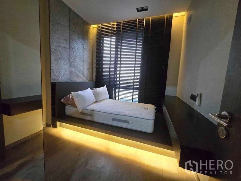 Condominium for rent - Second bedroom with raised platform bed, warm under-bed lighting and window blinds.