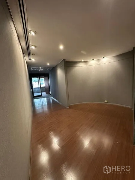 Office Space for rent in Watthana, Bangkok - Narrow gallery-style hall with wood floor, spotlights and a glass door