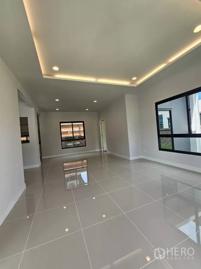 บ้าน ขายในLam Luk Ka, Pathum Thani - ห้องนั่งเล่นโปร่งสว่าง เพดานซ่อนไฟ พื้นกระเบื้องเงา
