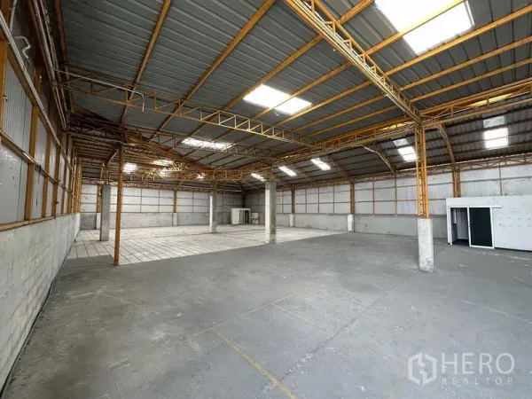 货栈 出租在Mueang Pathum Thani, Pathum Thani - 仓库内部通透，钢结构高屋顶配天窗，混凝土地面并带一处瓷砖区域。