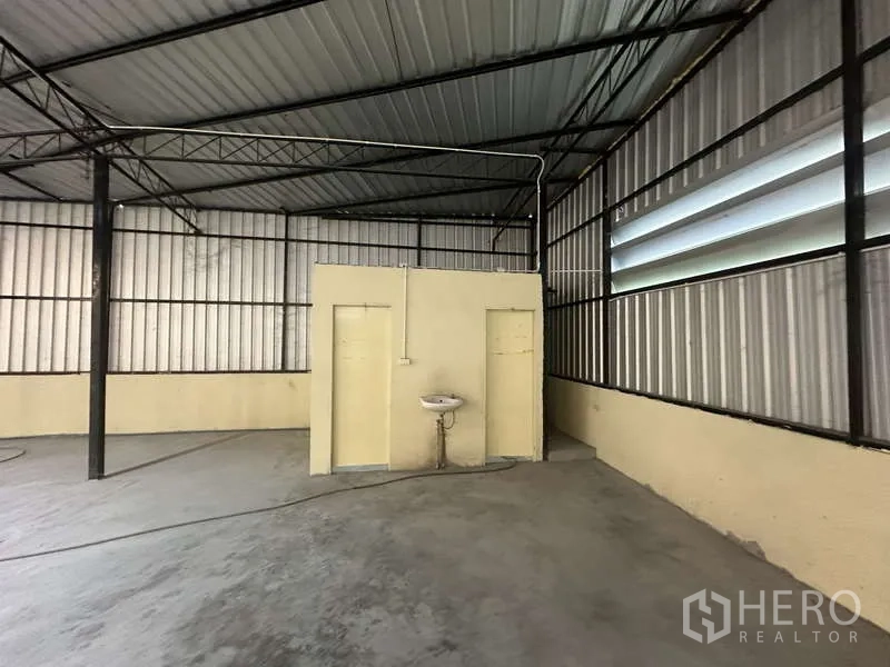 Warehouse for rent in Pak Kret, Nonthaburi - Warehouse corner featuring two restrooms and a wall-mounted sink.