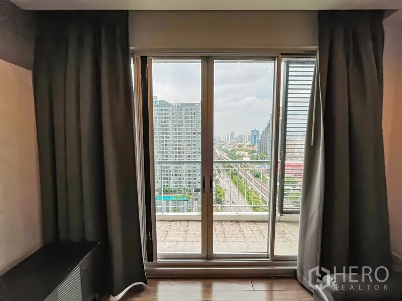 คอนโด ขาย - ประตูกระจกบานเลื่อนเปิดสู่อาระเบียง มองเห็นวิวสกายไลน์กรุงเทพฯ
