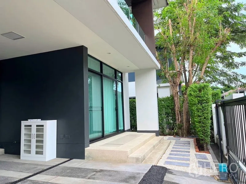 Detached House for rent in Bang Kapi, Bangkok - Side terrace with steps, tall hedges and sliding glass doors