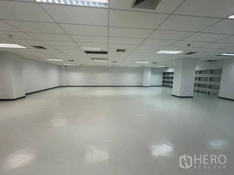 办公空间 出租在Bang Rak, Bangkok - 宽敞办公楼层，白色墙面、少量立柱，后方设有整排内置置物架。