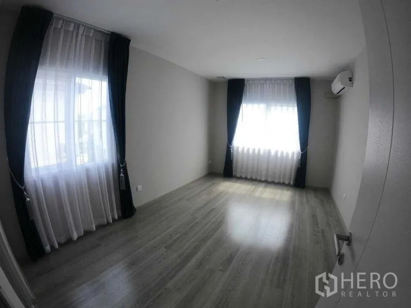 Townhouse for rent - Spacious second bedroom with two bright windows and wood floors.