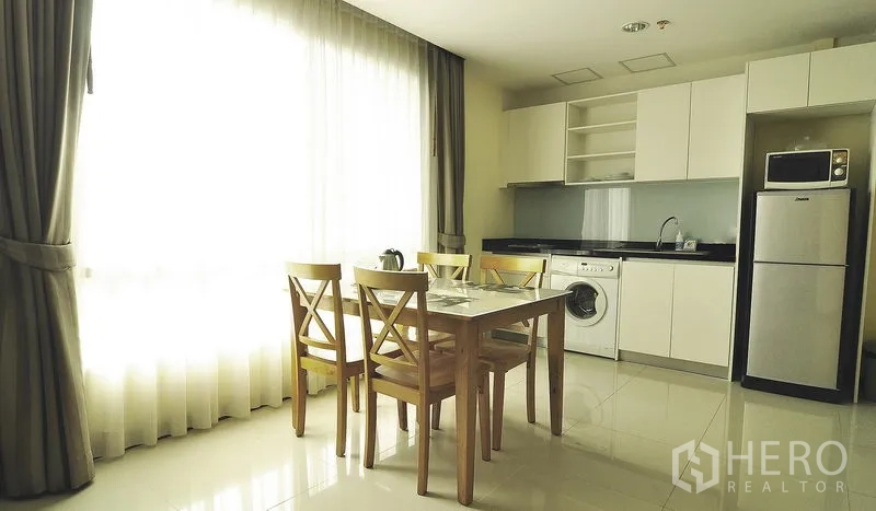 อพาร์ทเมนท์ ให้เช่าในKhlong Toei, Bangkok - มุมครัวบิวท์อินพร้อมตู้เก็บของ ตู้เย็น ไมโครเวฟ และเครื่องซักผ้าข้างชุดโต๊ะอาหาร