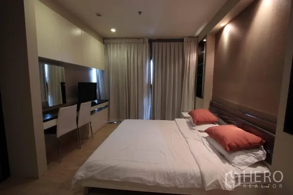 公寓 出租在Khlong Toei, Bangkok - 主卧配大床、整墙书桌与衣柜、电视及遮光窗帘