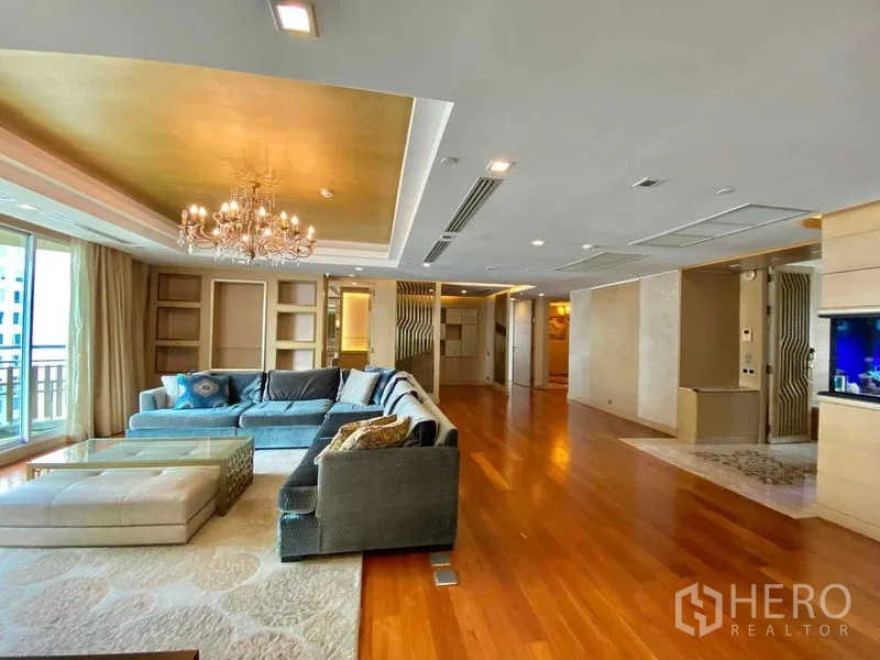 คอนโด ให้เช่าในKhlong Toei, Bangkok - ห้องนั่งเล่นหรู โซฟา L-shape โคมระย้า และทางออกสู่ระเบียง