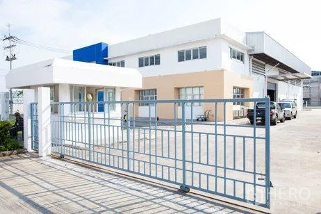 Factory for rent in Chachoengsao - Main entrance gate with guardhouse and parking area at the factory front.