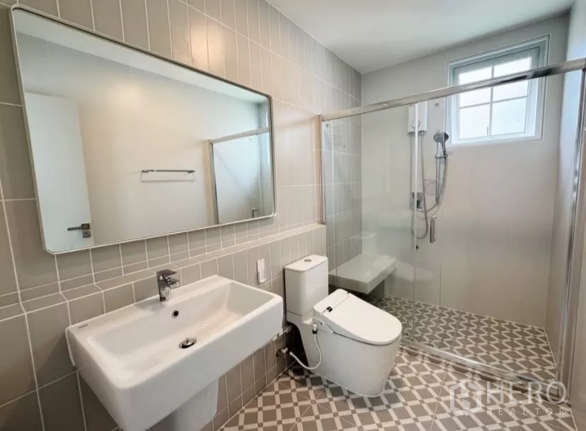 บ้าน ให้เช่าในBang Phli, Samut Prakan - ห้องน้ำผนังสีเบจ พื้นลายกราฟิก พร้อมฉากกั้นอาบน้ำ