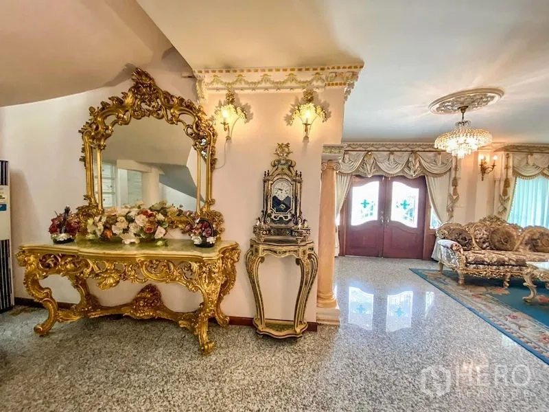 独立式住宅 出租或出售在Bang Khen, Bangkok - 门厅设金色雕花镜台与古典座钟，通向正式客厅区。