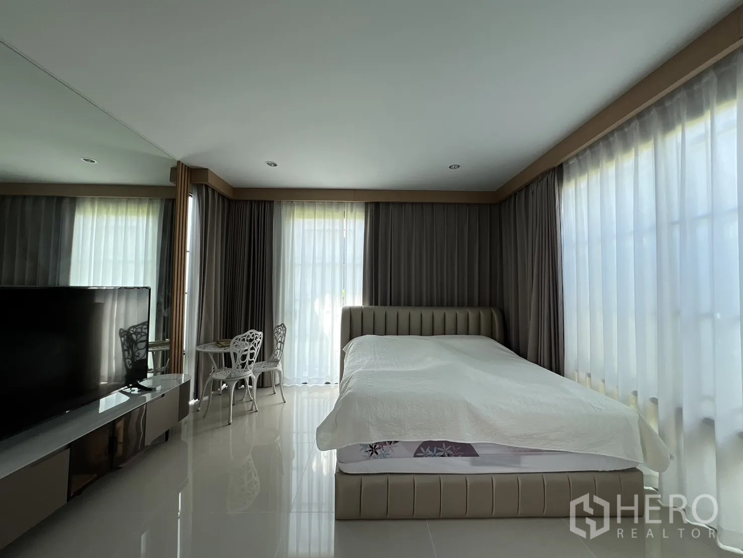 Detached House for rent or sale in Mueang Pathum Thani, Pathum Thani - Corner guest suite with wraparound windows and glossy tiled floor.