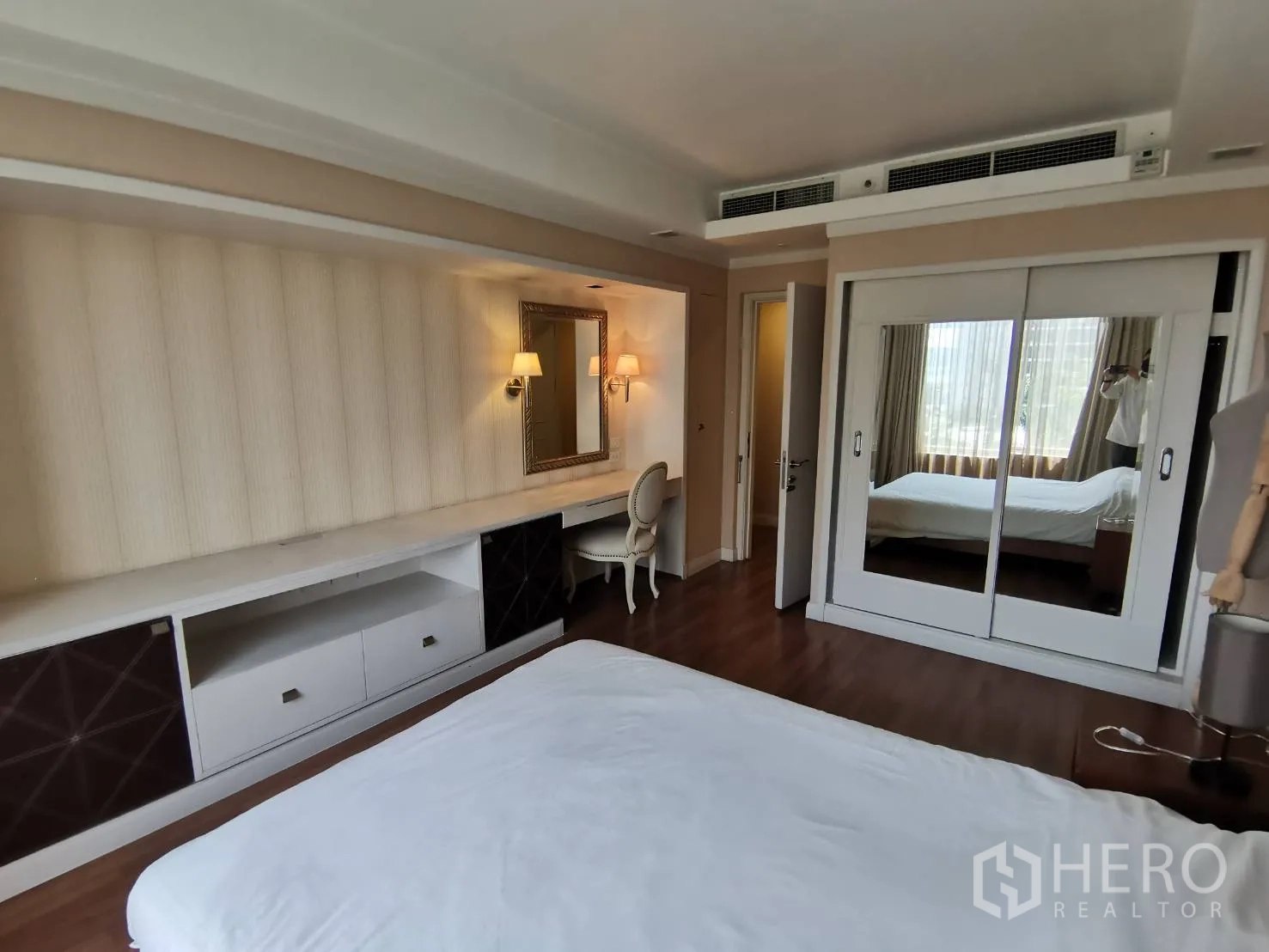 คอนโด ให้เช่าในPathum Wan, Bangkok - ห้องนอนหลักมีโต๊ะแต่งตัวบิวท์อิน ตู้เสื้อผ้าบานกระจก พื้นไม้ และแสงไฟอบอุ่น
