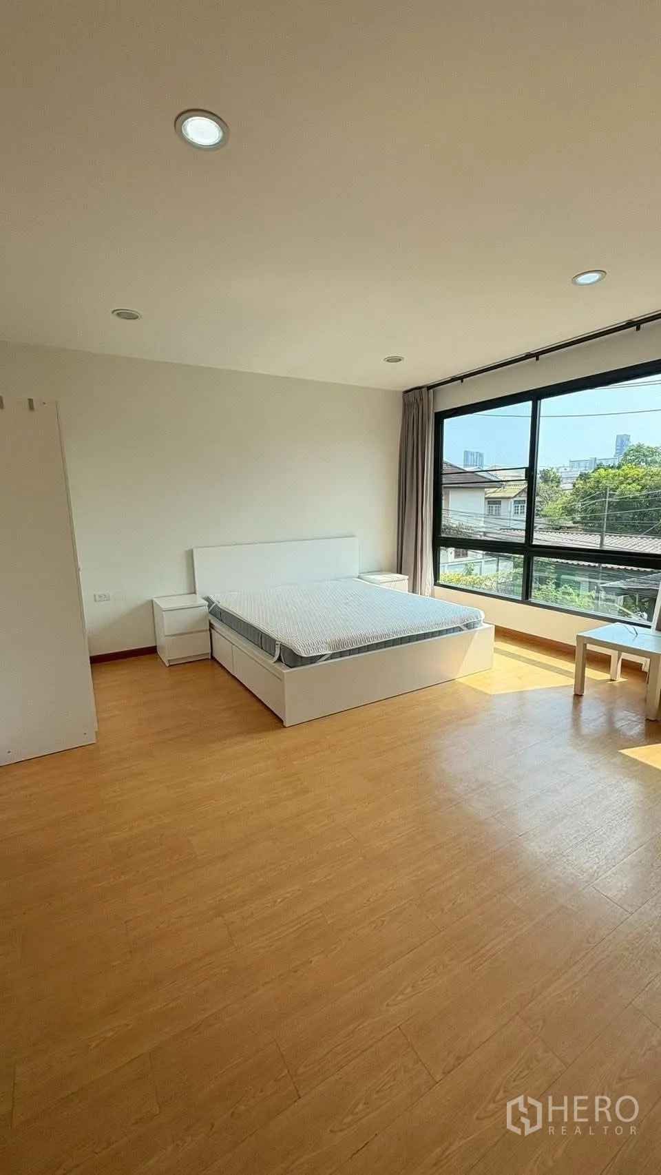 联排别墅 for rent in Phra Khanong, Bangkok - 大卧室，木地板、落地大窗和双人床。