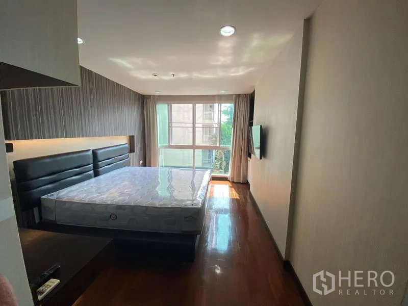 คอนโด ให้เช่าในWatthana, Bangkok - ห้องนอนสว่างพร้อมเตียงขนาดใหญ่ พื้นไม้ และหน้าต่างบานกว้างมองเห็นต้นไม้