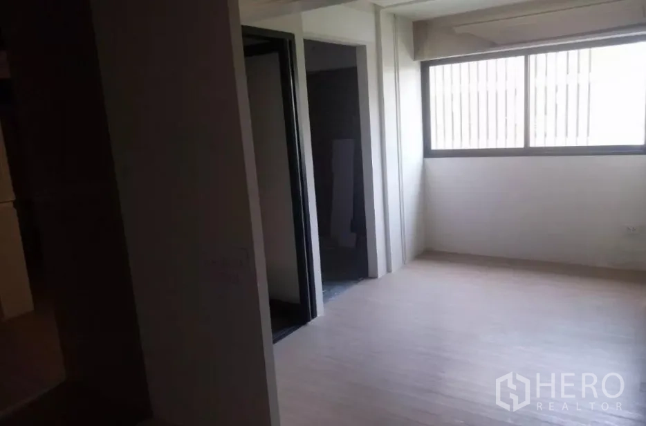 พื้นที่ขายปลีก ให้เช่า - มุมห้องมีหน้าต่างบานใหญ่และทางเข้า พื้นลามิเนตโทนอ่อน