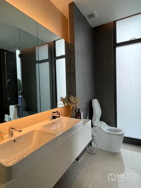 Home Office for sale in Prawet, Bangkok - Modern bathroom with double vanity, illuminated mirror, and smart toilet.