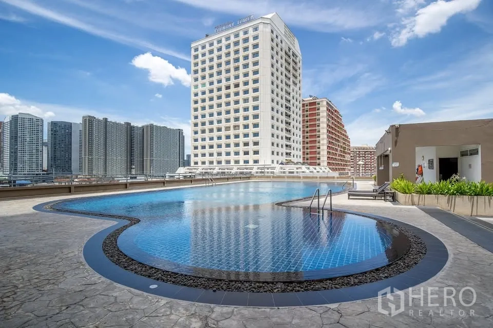 คอนโด ขายในBang Na, Bangkok - สระว่ายน้ำขนาดใหญ่บนดาดฟ้า เห็นวิวสกายไลน์และเตียงอาบแดด