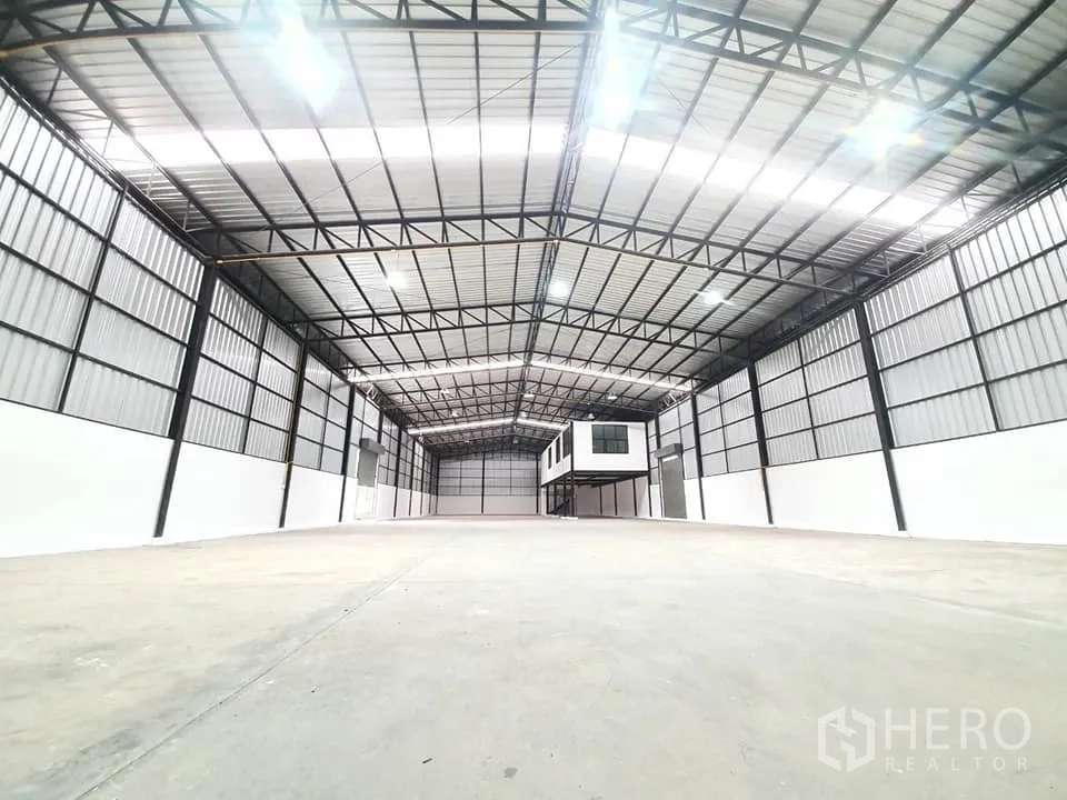 货栈 出租在Bang Khen, Bangkok - 高挑库房的广角视图，平整混凝土地面与金属墙板。
