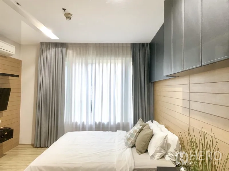 คอนโด ให้เช่าในKhlong Toei, Bangkok - ห้องนอนรับแสงธรรมชาติ หน้าต่างบานกว้าง ผ้าม่านโปร่ง ผนังลายไม้ ชุดเครื่องนอนสีขาว และตู้แขวนด้านบน