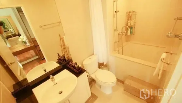 Condominium for rent or sale in Watthana, Bangkok - Bright bathroom with bathtub, shower, vanity sink and toilet in a modern condo.