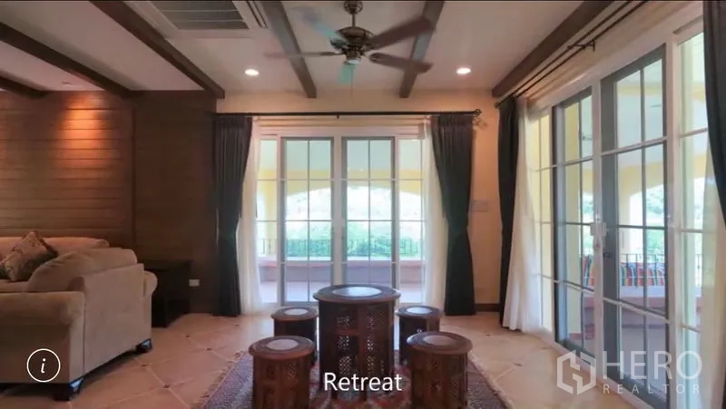 Detached House for rent or sale in Bang Phli, Samut Prakan - Second lounge retreat with French doors on two sides opening to a covered terrace and greenery.