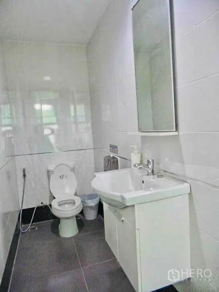 带办公室的家 出租或出售在Din Daeng, Bangkok - 四层现代建筑外立面，大面积玻璃与架空停车位。