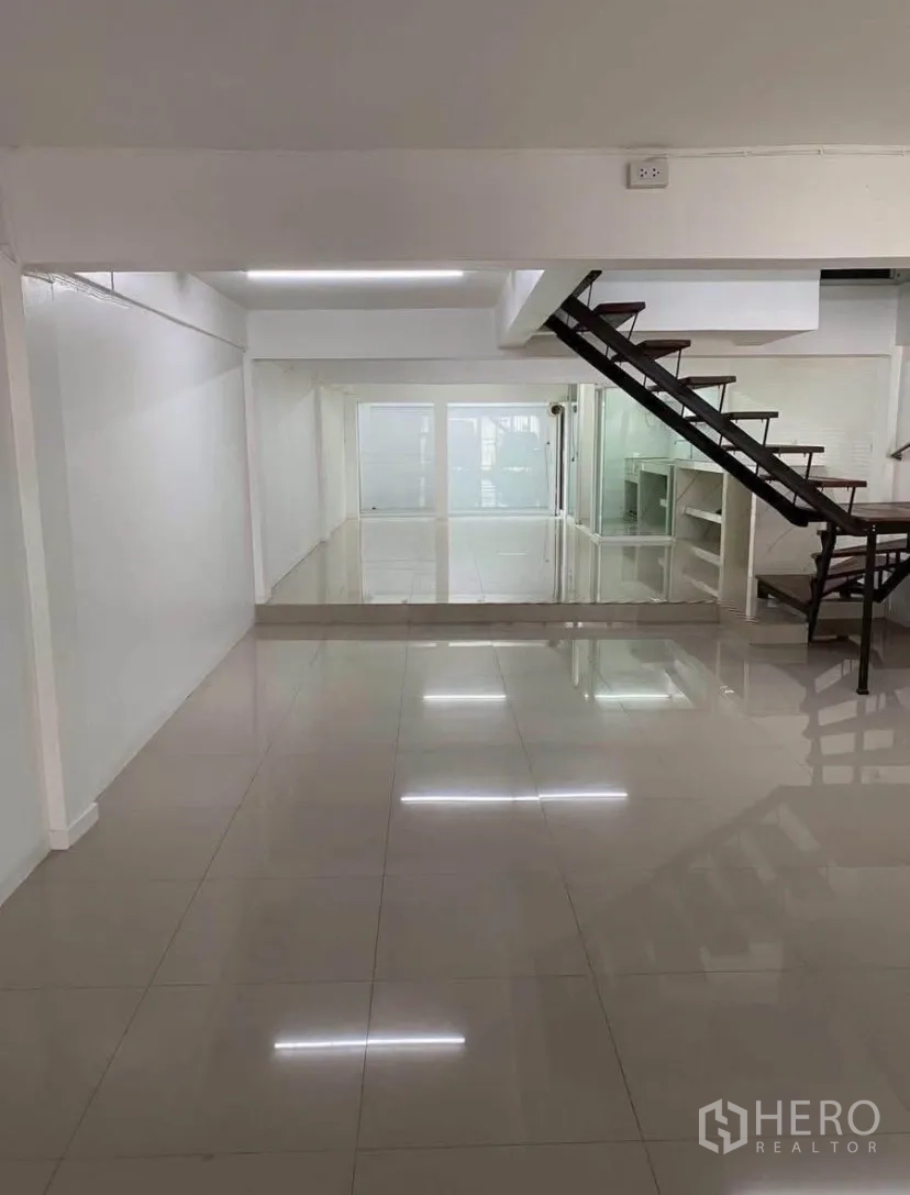联排别墅 for rent in Phra Khanong, Bangkok - 明亮开放式起居区，光泽地砖与现代楼梯。