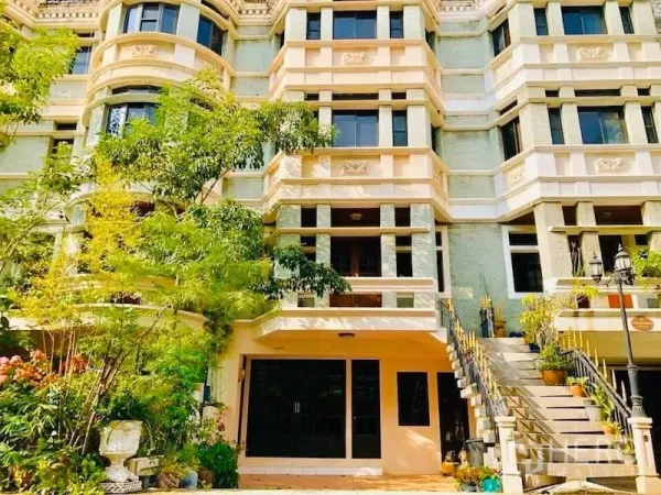 Townhouse for rent in Watthana, Bangkok - Multi-storey townhouse facade with balconies, trees and an external staircase in Watthana.