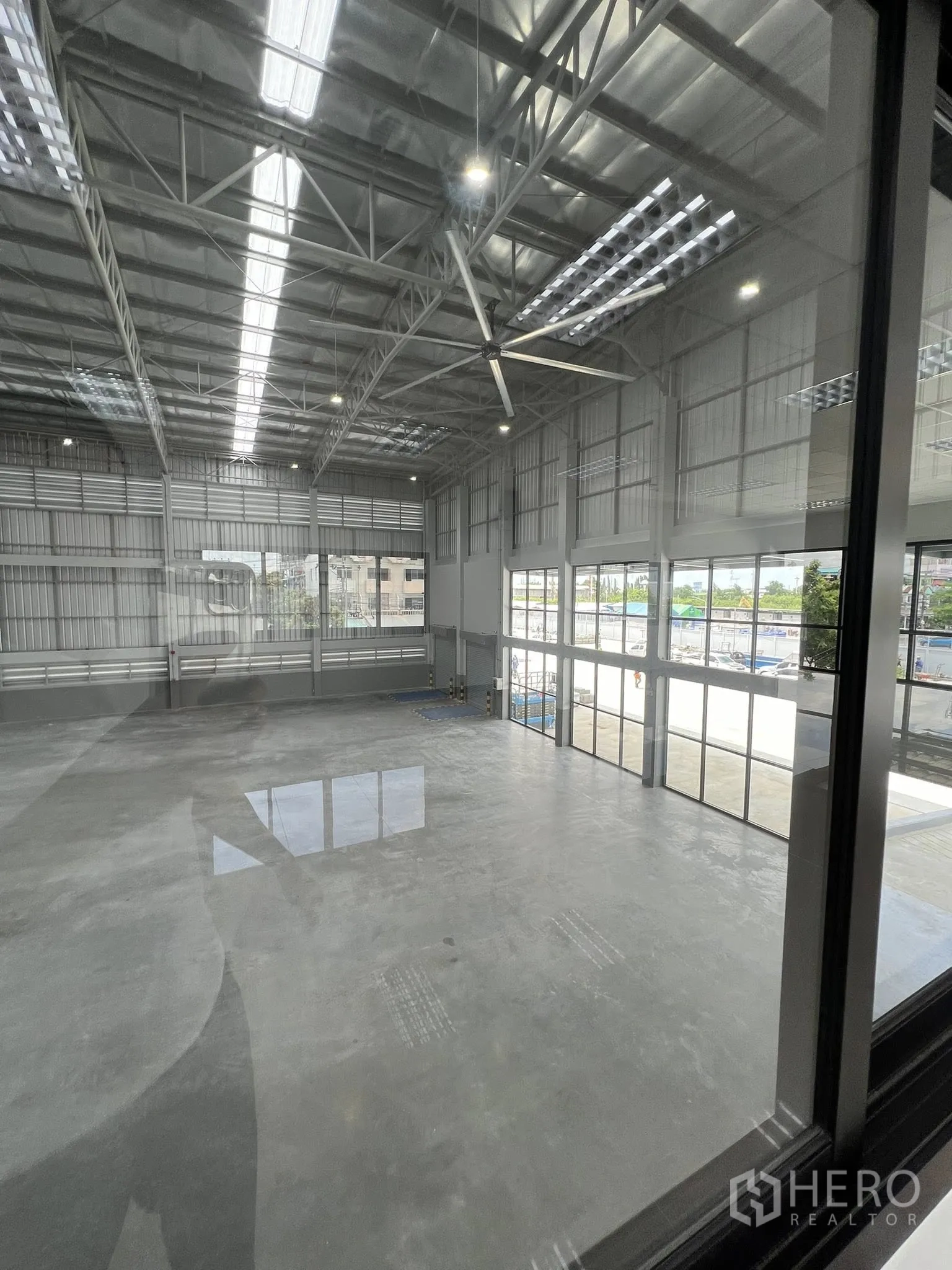 Warehouse for rent in Phra Pradaeng, Samut Prakan - View from the office over the warehouse floor, roof trusses and glazed entry.