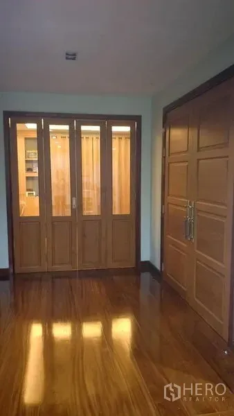 Home Office for sale in Phasi Charoen, Bangkok - Entrance hall with polished wooden floor, paneled doors and a glass room divider.