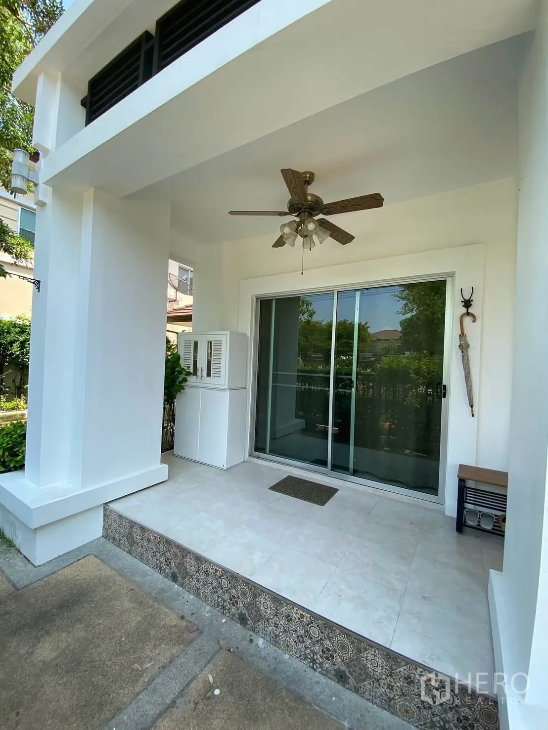 Detached House for rent in Mueang Samut Prakan, Samut Prakan - Covered front terrace with ceiling fan and sliding glass door.