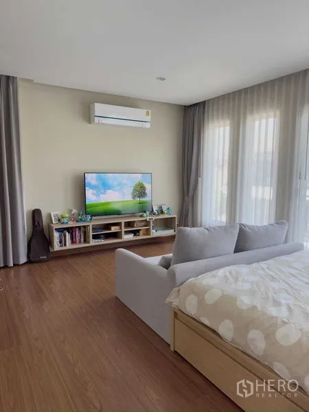 บ้าน ให้เช่าหรือขายในBang Khen, Bangkok - มุมห้องนอนมาสเตอร์อีกด้าน พร้อมชั้นวางทีวี ผ้าม่าน และพื้นไม้