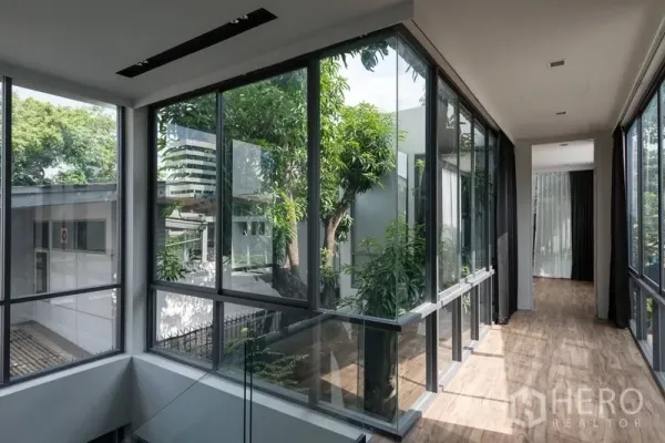 Office Space for rent in Watthana, Bangkok - Upper corridor with full-height windows overlooking mature trees and city views.