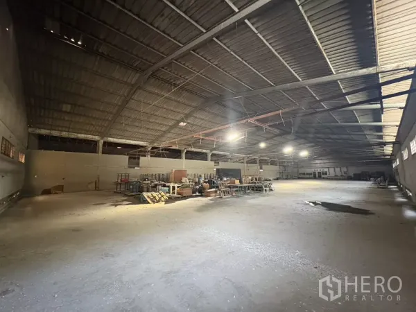 Warehouse for rent in Khlong Toei, Bangkok - Large open warehouse floor with overhead lighting and metal roof trusses.