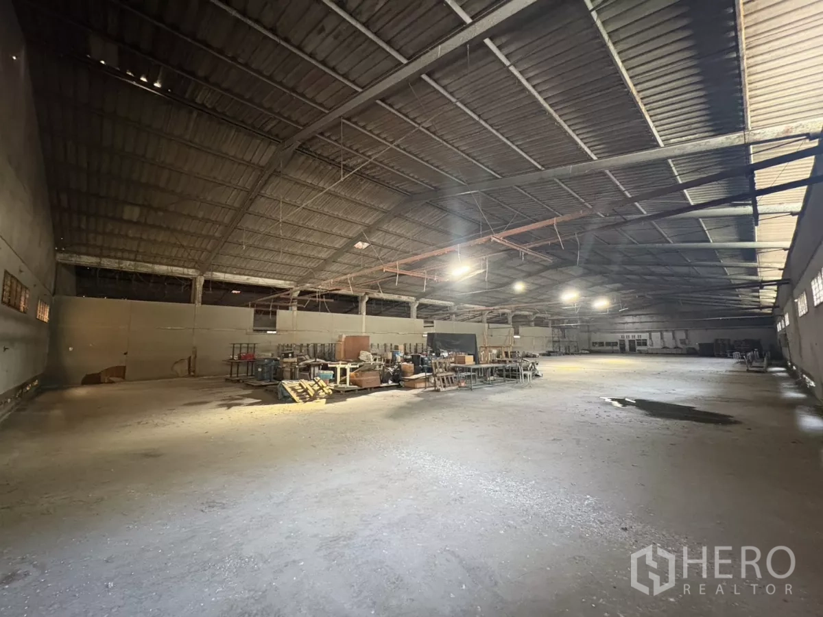 Warehouse for rent in Khlong Toei, Bangkok - Large open warehouse floor with overhead lighting and metal roof trusses.