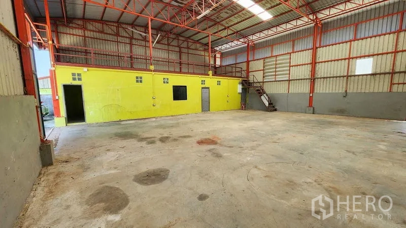 货栈 出租在Nong Chok, Bangkok - 仓库内部挑高空间，红色钢梁屋架，混凝土地面与夹层办公室。