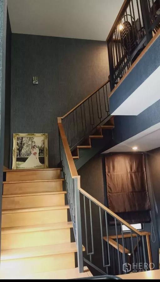 บ้าน ให้เช่าหรือขายในKhan Na Yao, Bangkok - บันไดไม้ราวเหล็กเชื่อมต่อขึ้นชั้นบนในโถงเพดานสูง