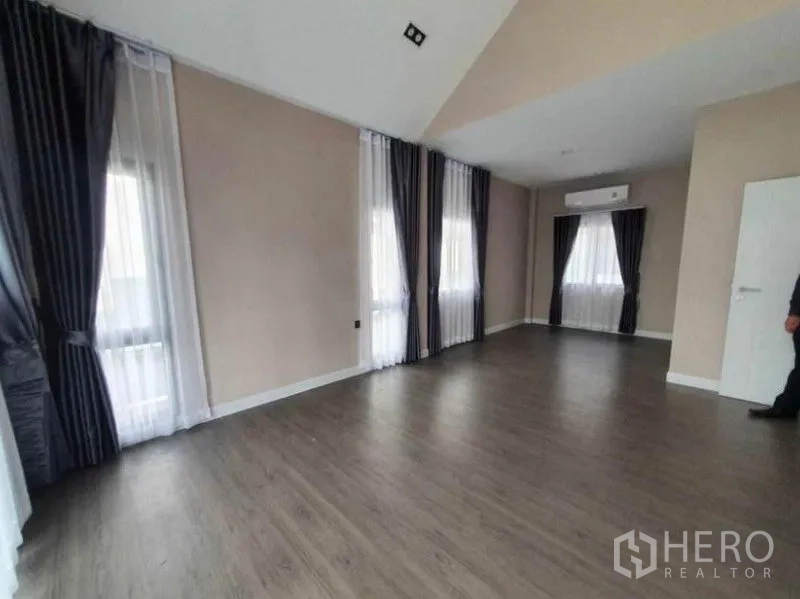 Detached House for rent in Lak Si, Bangkok - Upper-floor bedroom with wood flooring, multiple windows, blackout drapes and air-conditioning.