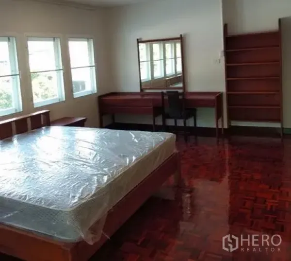 อพาร์ทเมนท์ ให้เช่าในPathum Wan, Bangkok - มุมห้องนอนพร้อมโต๊ะเครื่องแป้ง กระจก ชั้นวาง และหน้าต่างบานใหญ่เหนือพื้นปาร์เกต์