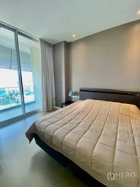 คอนโด ให้เช่าหรือขายในPathum Wan, Bangkok - ห้องนอนมินิมอล ประตูกระจกบานเลื่อนขนาดใหญ่เชื่อมสู่ระเบียงและวิวสกายไลน์.