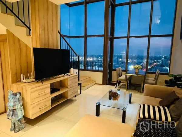 คอนโด ให้เช่าในBangkok - ห้องนั่งเล่นพร้อมตู้วางทีวี โต๊ะกลางกระจก และผนังกระจกพาโนรามา