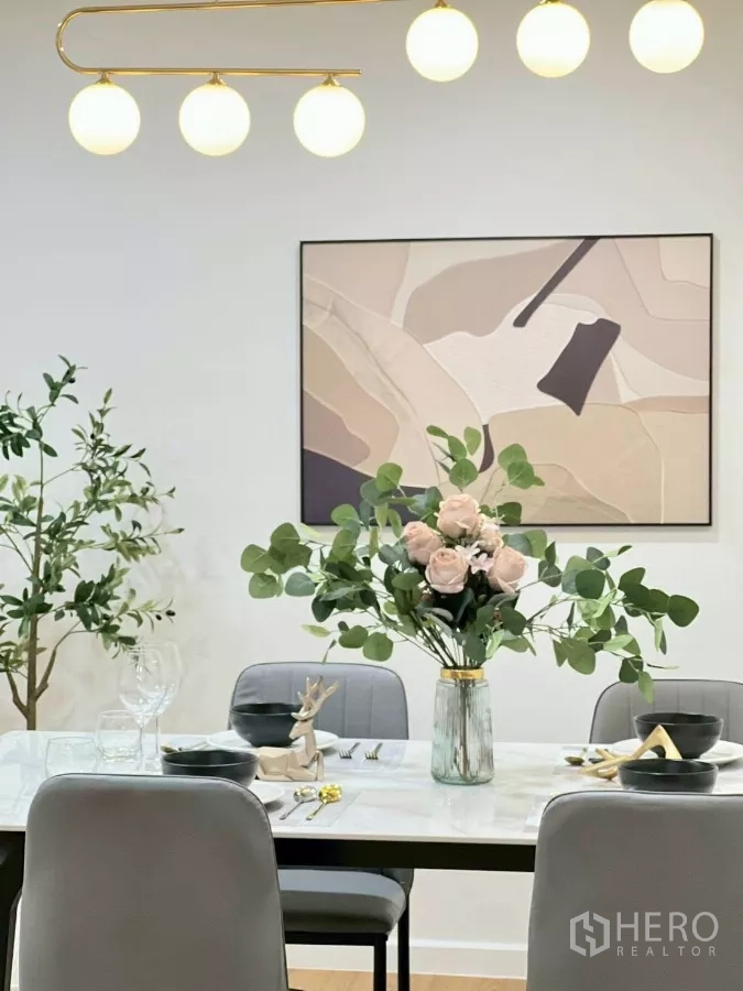 บ้าน ให้เช่าในHuai Khwang, Bangkok - ภาพศิลปะและโคมไฟระย้าเหนือโต๊ะอาหารพร้อมแจกันดอกไม้