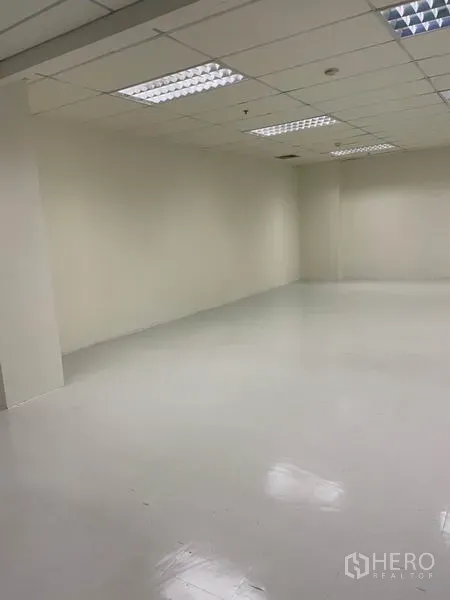Office Space for rent in Khlong Toei, Bangkok - Angled view of clean open-plan office space with smooth white floor, neutral walls and tiled ceiling.