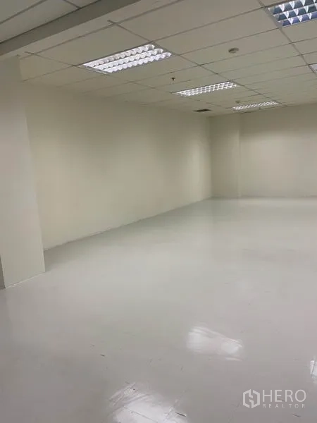 Office Space for rent in Khlong Toei, Bangkok - Angled view of clean open-plan office space with smooth white floor, neutral walls and tiled ceiling.